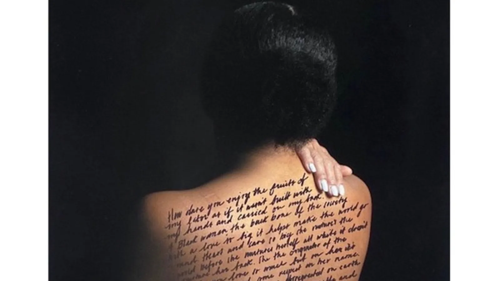 Photo of a dark-haired woman with her bare back to the camera and a hand over her shoulder, words written across her back