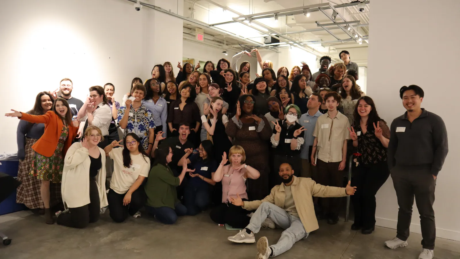 30+ members of Urban Arts Space staff and interns posing and smiling on the gallery steps
