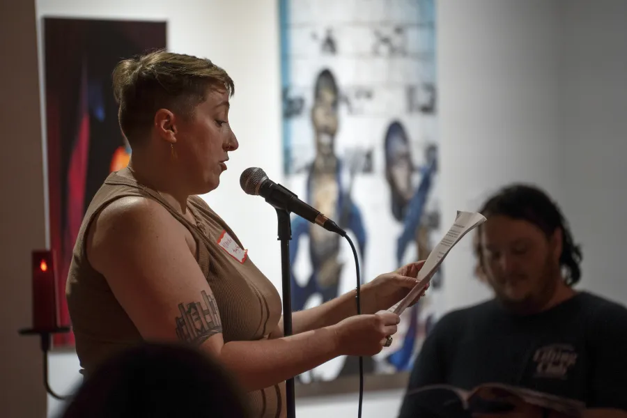 A person standing at a microphone reading from a paper