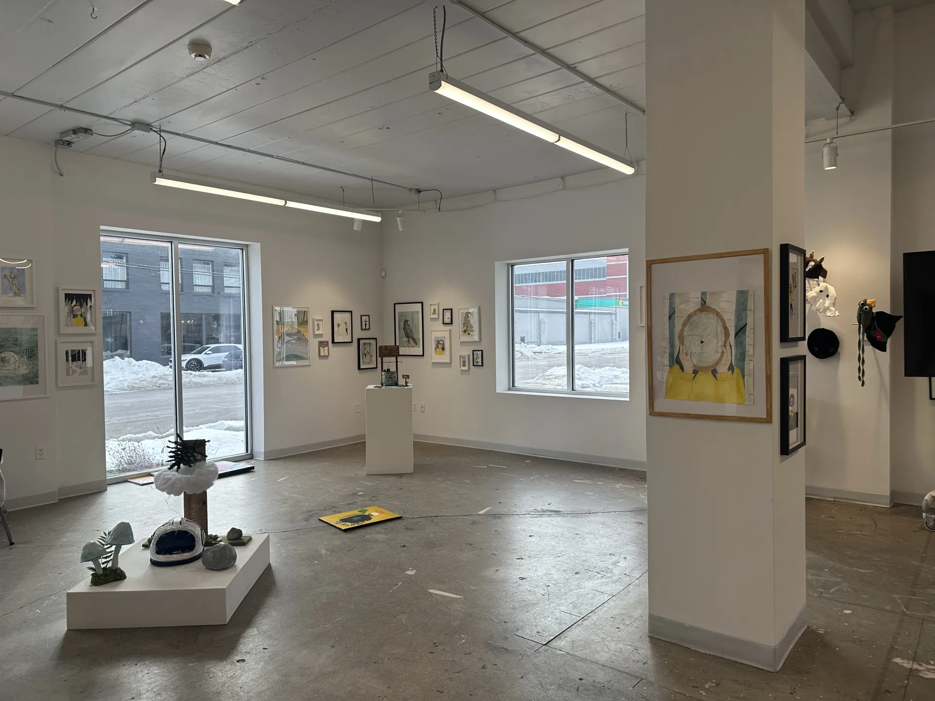 well-lit gallery space with sculptures and paintings