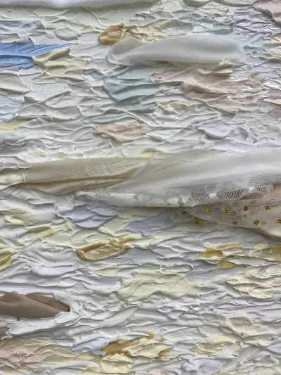 Close up of fabric art piece by Madeline with purple, white, and beige fabric