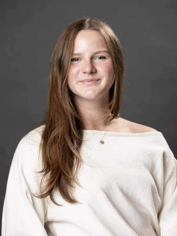 Grace smiling in a white sweater