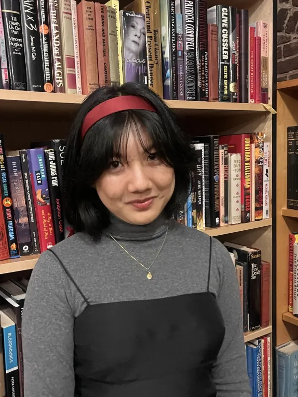 Tiffany smiling in front of a bookshelf